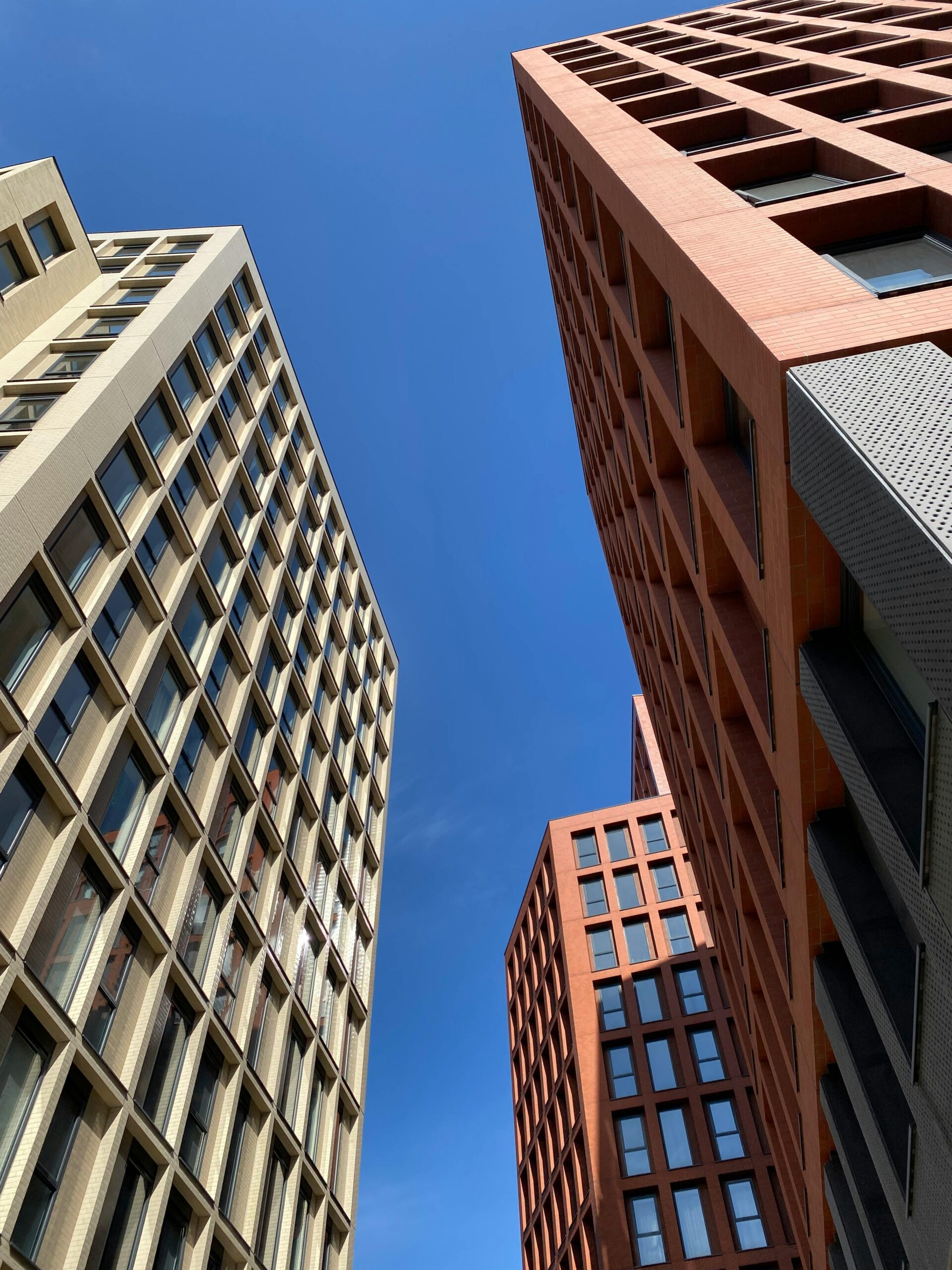 Contemporary architecture of skyscrapers against a clear blue sky in Manchester, UK.